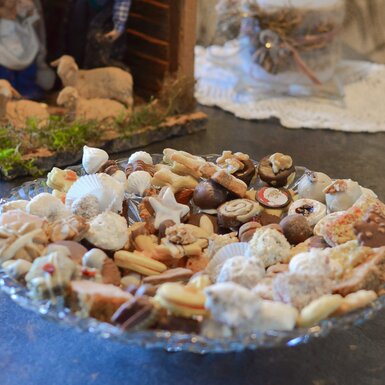 Kekse liegen in einer Glasschale vor einer Grippe und Kerze | © Laura Neißl / Urlaub am Bauernhof