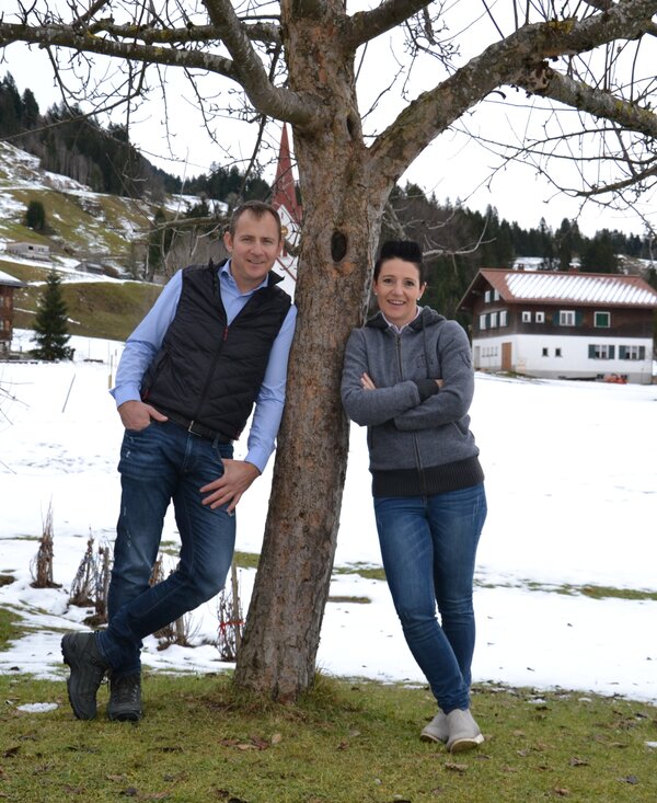 Bauer und Baeuerin lehnen am Baum | © Urlaub am Bauernhof Österreich / Dorner Bauer und Baeuerin lehnen am Baum vor verschneiter Wiese | © Urlaub am Bauernhof Österreich / Dorner