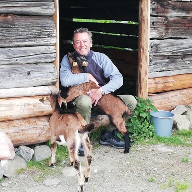Mann umarmt Ziegen | © Urlaub am Bauernhof Österreich