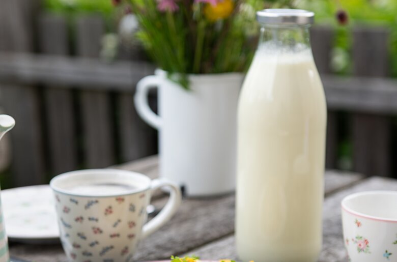 Frische Eierspeise mit einem Liter Milch und Wiesenblumenstrauß im Hintergrund | © Carlettophotography/Urlaub am Bauernhof SalzburgerLand