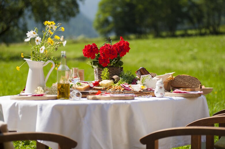 Gedeckter Tisch mit regionalen Produkten vom Bauernhof im Freien | © Urlaub am Bauernhof / punkt&komma