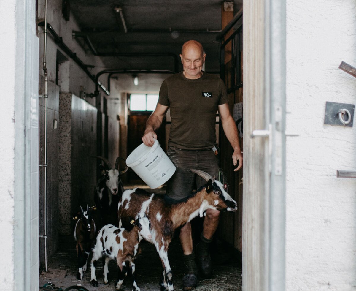 Mann im Stall mit Ziegen | © Urlaub am Bauernhof/ Nadja Jabli Mann im Stall mit Ziegen | © Urlaub am Bauernhof/ Nadja Jabli