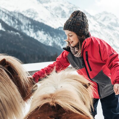 Kind streichelt ein Pony. | © Urlaub am Bauernhof im SalzburgerLand/ Punkt und Komma Kind streichelt ein Pony. | © Urlaub am Bauernhof im SalzburgerLand/ Punkt und Komma