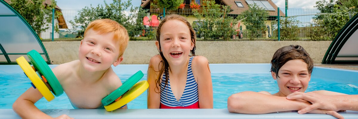 Drei Kinder am Beckenrand im Pool, Oststeiermark, Steiermark | © Urlaub am Bauernhof Steiermark / Wolfgang Spekner