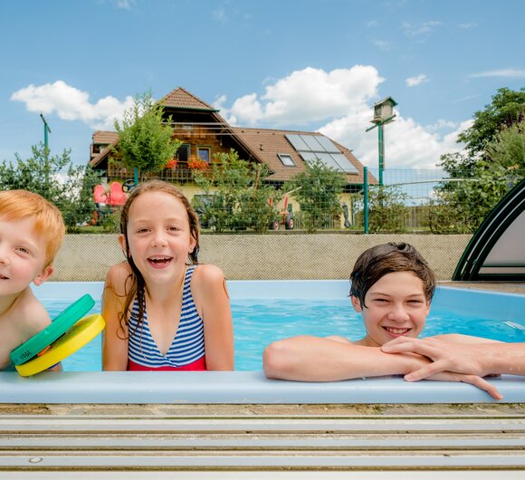Drei Kinder am Beckenrand im Pool, Oststeiermark, Steiermark | © Urlaub am Bauernhof Steiermark / Wolfgang Spekner