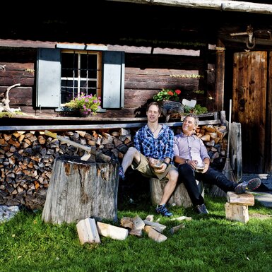 Zwei Männer vor der Hütte nach dem Holzhacken, Steiermark | © Urlaub am Bauernhof Steiermark / Kufferath Zwei Männer sitzen nach dem Holzhacken vor der Hütte, Steiermark | © Urlaub am Bauernhof Steiermark / Kufferath