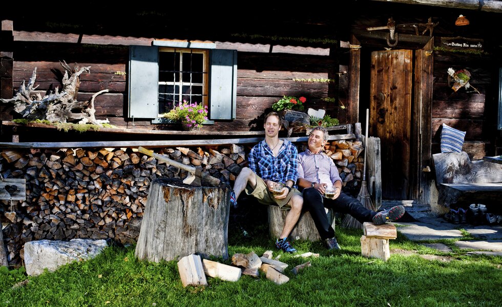 Zwei Männer sitzen nach dem Holzhacken vor der Hütte, Steiermark | © Urlaub am Bauernhof Steiermark / Kufferath