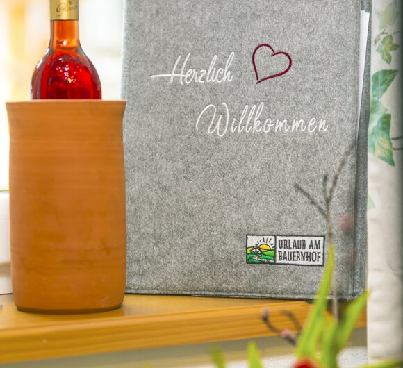 Gästemappe von Urlaub am Bauernhof mit Wein als Willkommensgeschenk | © Urlaub am Bauernhof Steiermark / Elisabeth Fröhlich Photography