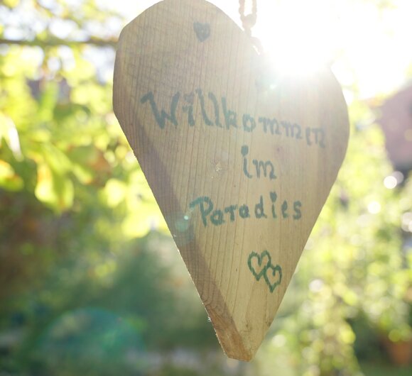 Ein Holzherz mit der Aufschrift Herzlich Willkommen hängt im Obstgarten an einem Baum | © Urlaub am Bauernhof Steiermark / Daniel Gollner