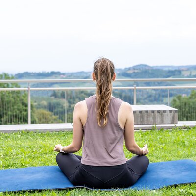 Eine Frau beim Yoga im Weingarten | © Urlaub am Winzerhof / Elisabeth Fröhlich