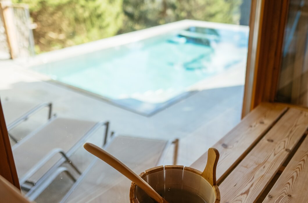 Saunkübel mit Schöpfkelle in der Sauna, Blick nach draußen auf den Swimmingpool | © Urlaub am Bauernhof / Daniel Gollner