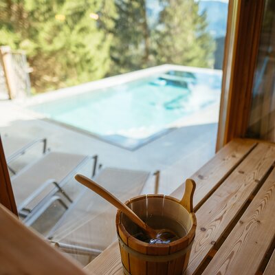 Saunkübel mit Schöpfkelle in der Sauna, Blick nach draußen auf den Swimmingpool | © Urlaub am Bauernhof / Daniel Gollner