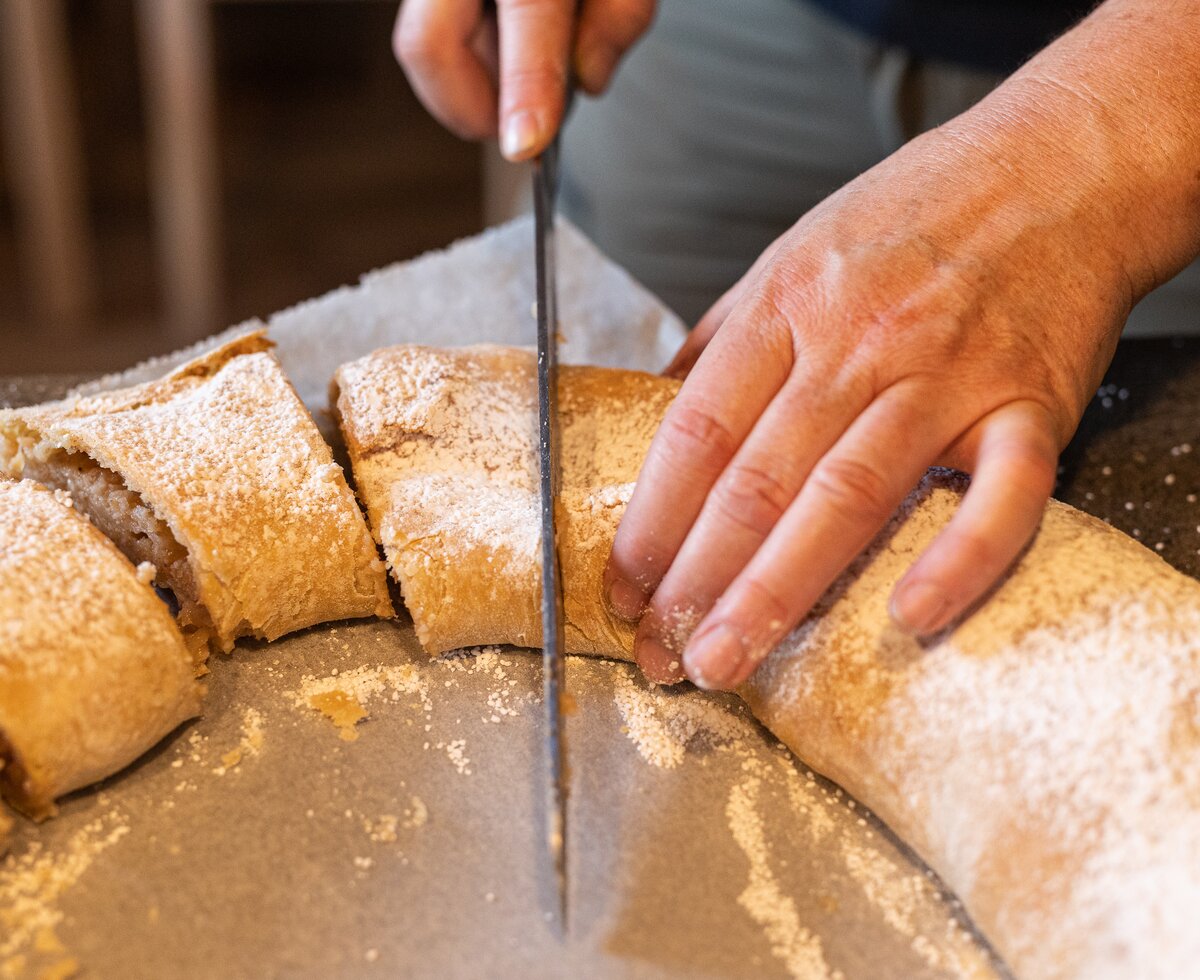 Apfelstrudel aufschneiden | © Urlaub am Bauernhof / Punkt & Komma Der frisch gebackene Strudel wird aufgeschnitten | © Urlaub am Bauernhof / Punkt & Komma