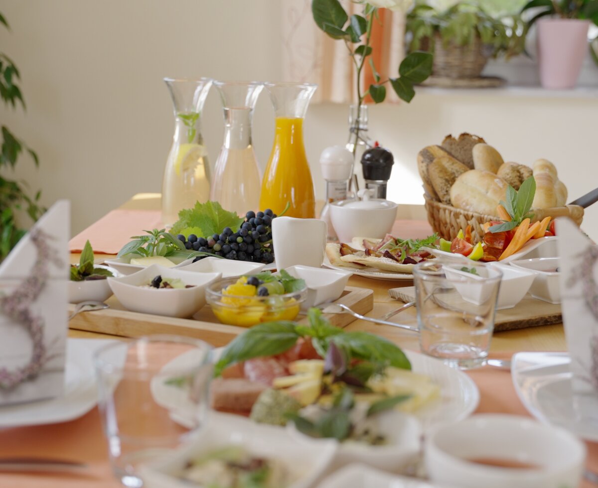 Liebevoll gedeckter Frühstückstisch | © Urlaub am Bauernhof / Daniel Gollner Liebevoll gedeckter Frühstückstisch mit Aufstrichen, Marmelade, Honig und Früchten in kleinen Schälchen, im Hintergrund stehen Karaffen mit Wasser und Orangensaft und ein Gebäckkorb | © Urlaub am Bauernhof / Daniel Gollner
