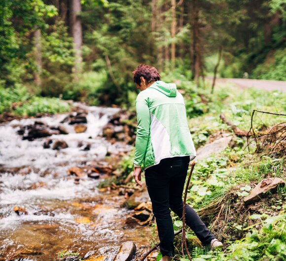Eine Frau an einem Bachlauf im Wald | © Urlaub am Bauernhof Steiermark / Daniel Gollner