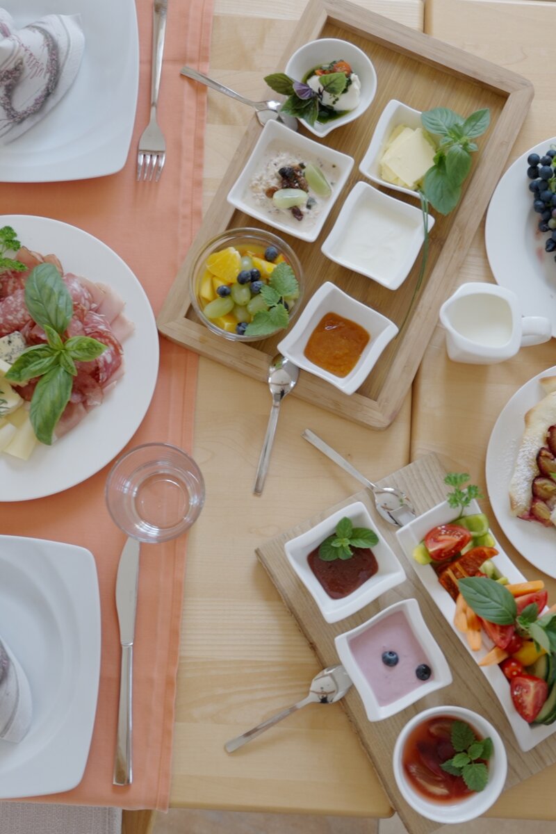 Gedeckter Frühstückstisch mit Joghurt, Obst, Marmelade, Butter, Aufstrich in kleinen Schälchen | © Urlaub am Bauernhof Steiermark, Daniel Gollner