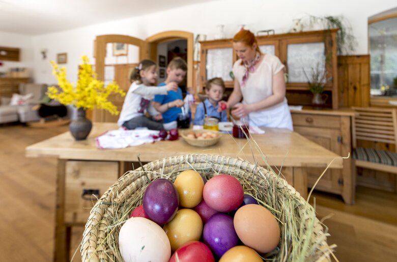 Die Kinder helfen fleißig beim Eierfärben, Steiermark | © Urlaub am Bauernhof Steiermark / Tom Lamm Die Kinder helfen beim Eierfärben, Korb mit gefärbten Eiern im Vordergrund, Steiermark | © Urlaub am Bauernhof Steiermark / Tom Lamm