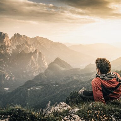 Ein Wanderer macht eine Rast und blickt auf die Berge | © TRV Gesäuse  / Stefan Leitner
