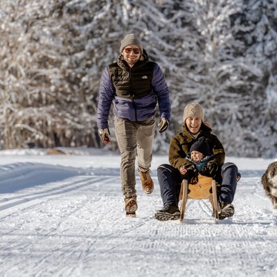 Familie fährt mit dem Schlitten in der Winterlandschaft | © UaB Steiermark / Wolfgang Spekner
