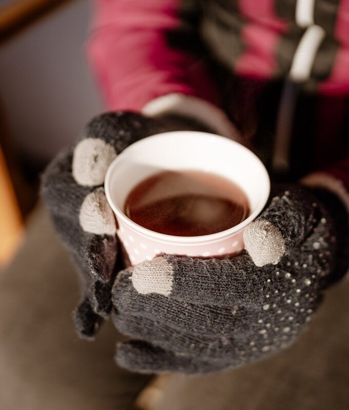 Eine Frau mit Handschuhen haltet eine Tasse warmen Tee im Winter | © UaB Steiermark / Wolfgang Spekner
