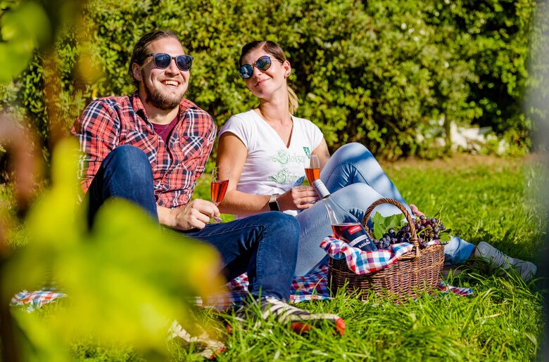 Ein Paar auf der Wiese im Weingarten beim Picknick mit Schilcher Frizzante, Süd-West-Steiermark, Steiermark | © Urlaub am Bauernhof Steiermark / Wolfgang Spekner