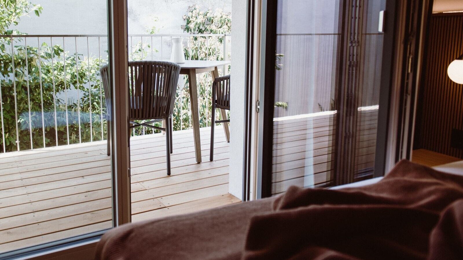 Großer Balkon des Weinlofts mit Tisch und Stühlen und Blick in den Innenhof.