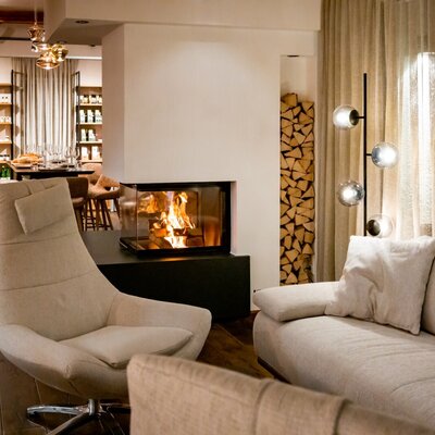 Der Wohnbereich im Bauernhof bietet einen Kamin mit Holzfeuer, gestapeltes Brennholz und bequeme Sitzgelegenheiten.