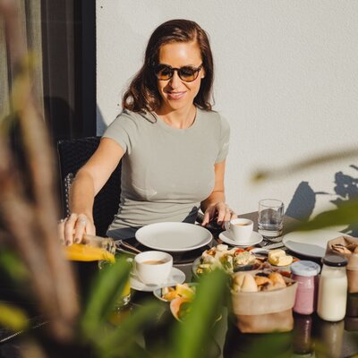 Frühstück im Freien auf der Terrasse des Bauernhofs mit einer Auswahl an Speisen und Getränken.