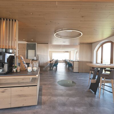 Aufenthaltsraum des Hofes mit Selbstbedienungs-Kaffeemaschine und verschiedenen Sitzbereichen.