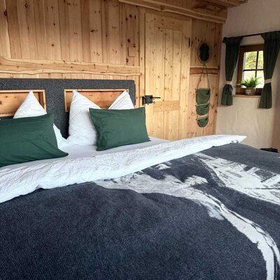 Das Panoramazimmer verbindet ein komfortables Doppelbett mit der warmen, natürlichen Ausstrahlung seiner Zirbenholzverkleidung.