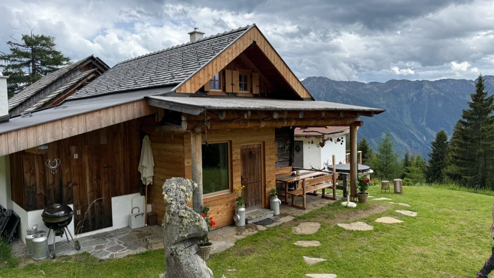Urige Alm mit einer gemütlichen Holzterrasse, Grillplatz und weitem Blick auf die umliegenden Berge.