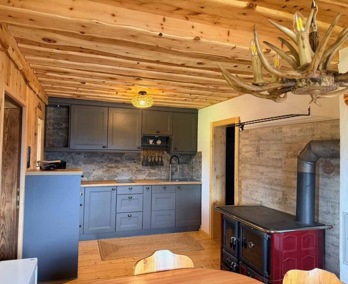 Die stilvolle Küche verbindet warme Holzelemente, eine moderne Küchenzeile und einen traditionellen Holzherd.
