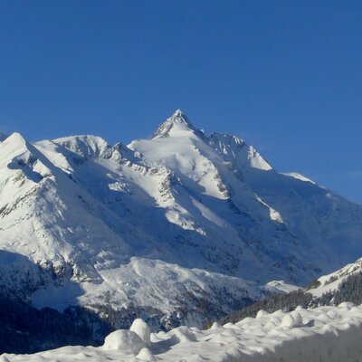 Die schneebedeckten Berge des Nationalparks Hohe Tauern bieten ideale Bedingungen für Winteraktivitäten rund um den Bauernhof.