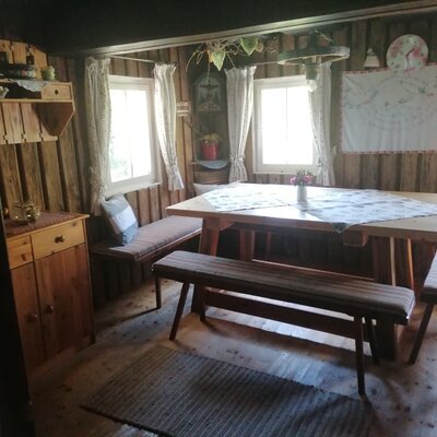 Der Essbereich der Alm ist ausgestattet mit einem Holztisch, Sitzbänken und Holzvertäfelung.