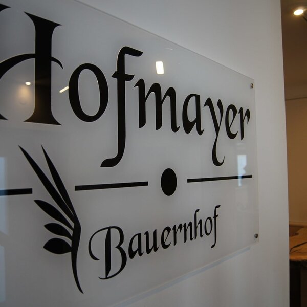 Das Hofmayer Bauernhof-Schild am Eingang heißt die Gäste willkommen.