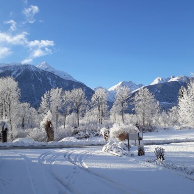 Blick auf die verschneite Berglandschaft und die Umgebung des Bauernhofs im Winter.