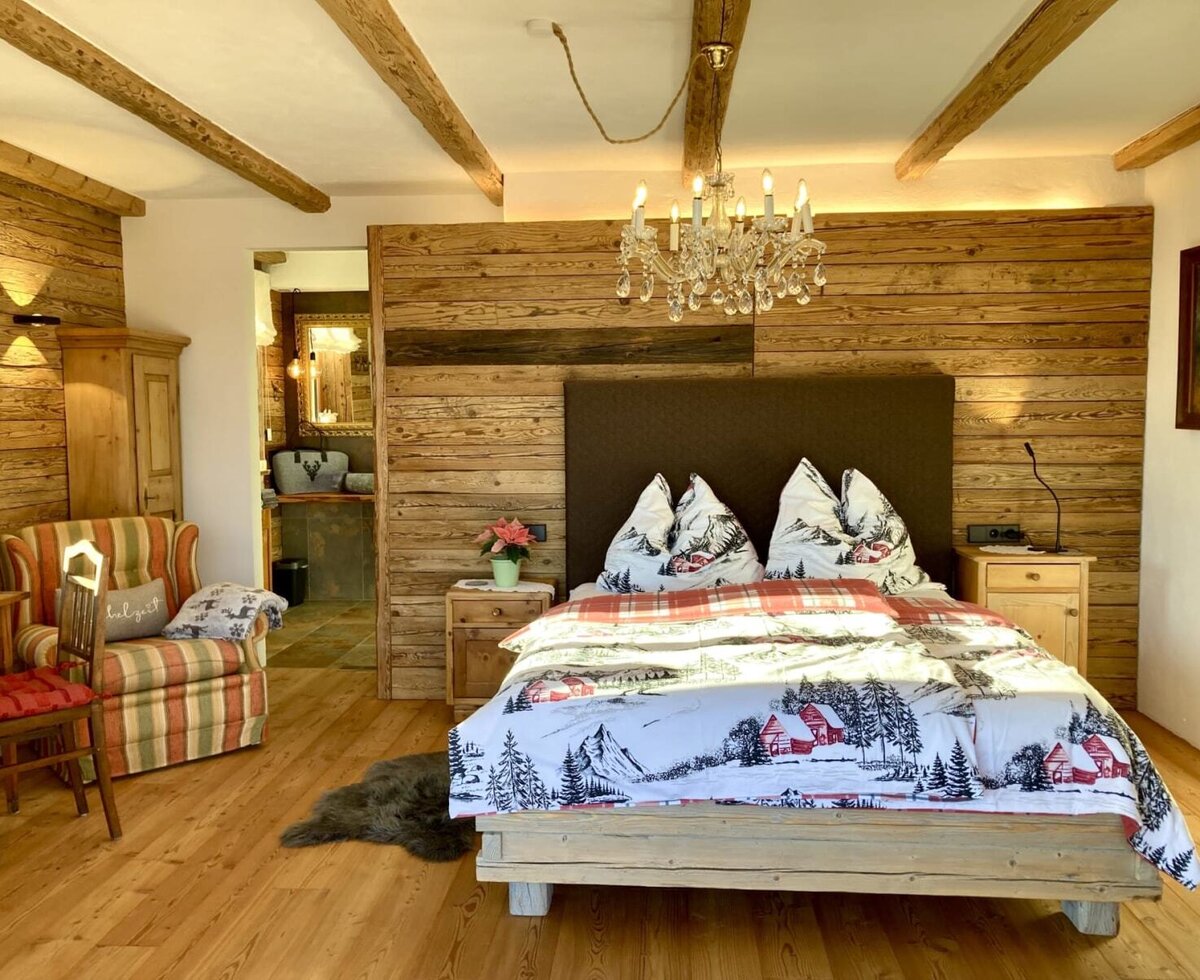 Großzügiges, urig-luxuriöses Schlafzimmer im Chalet mit Doppelbett und Zugang zum Bad en Suite