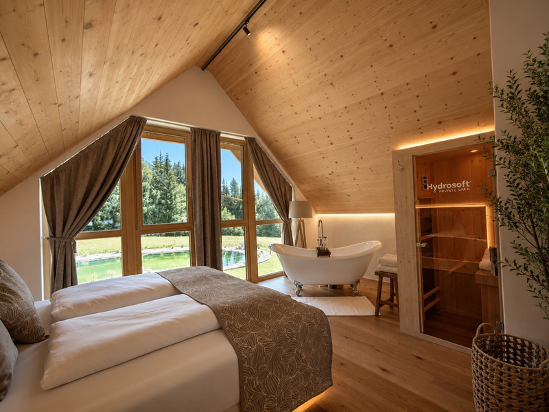 Schlafzimmer im privaten Naturhaus bei Ebner 1822 mit freistehender Badewanne, Infrarotkabine und Blick in die Natur