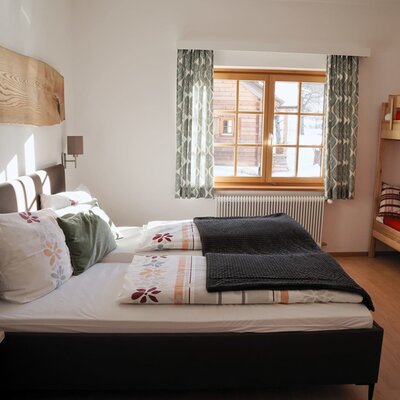 Familienzimmer im Bauernhof mit Doppelbett und einem Etagenbett.