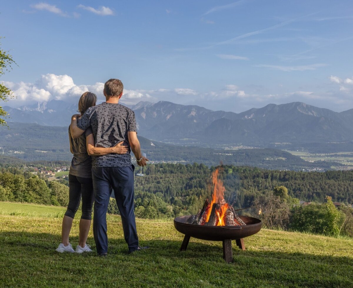 Die Feuerstelle im Freien des Bauernhofs mit Panoramablick auf die Berge und das Tal.