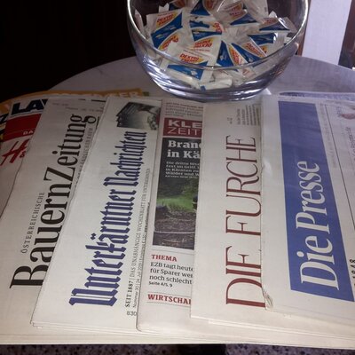 Verschiedene Zeitungen und eine Schale mit Dextro Energy stehen für die Gäste des Bauernhofs bereit.