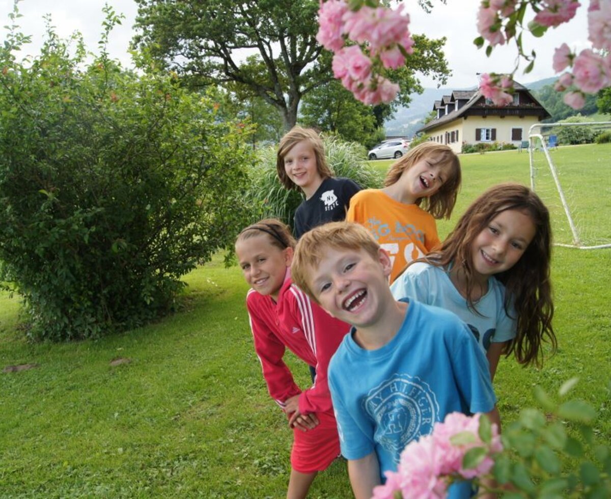 Kinder spielen auf der Rasenfläche des Bauernhofs mit einem Fußballtor.