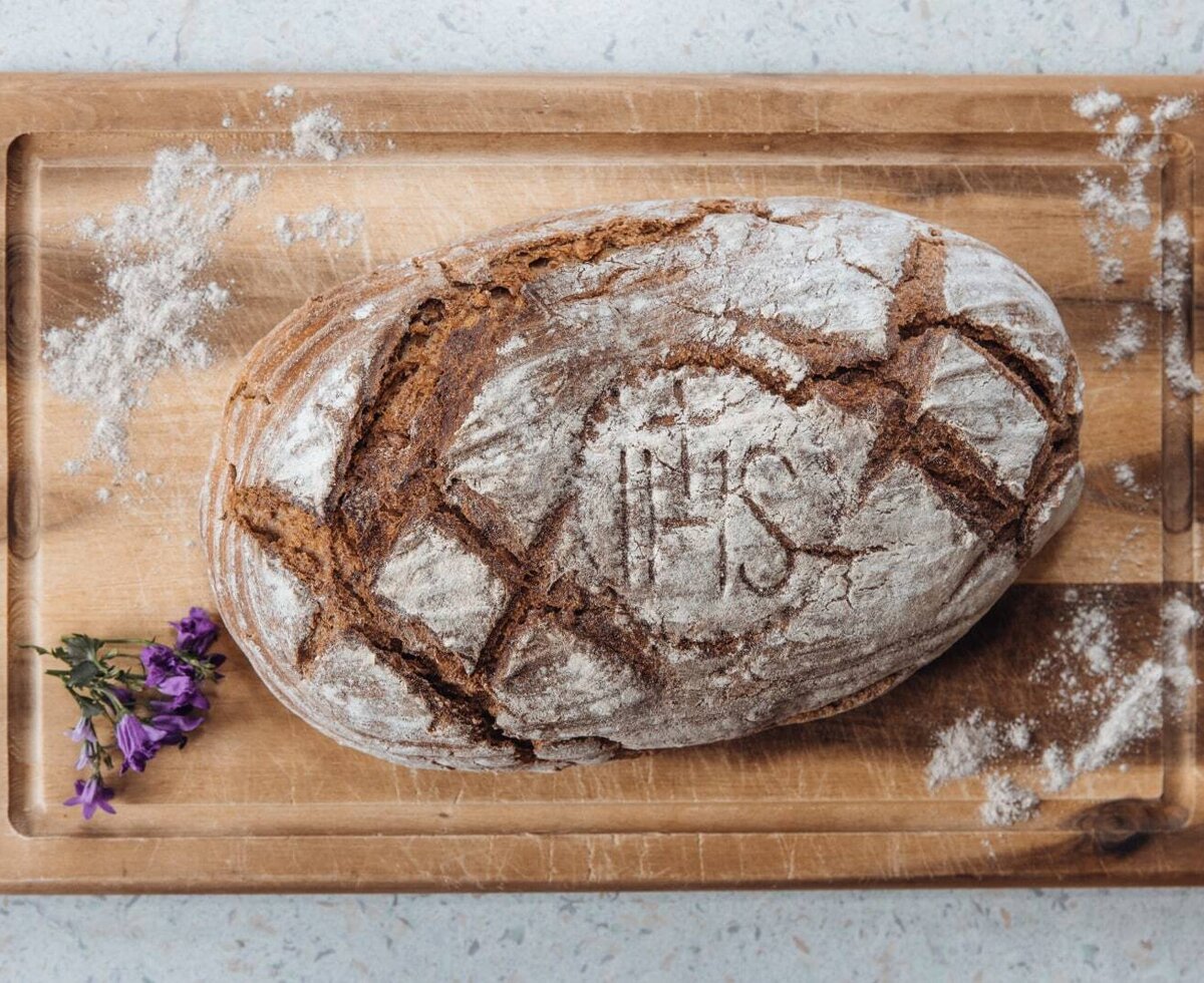 Frisch gebackenes Bauernbrot auf einem Holzbrett, typisch für den Bauernhof.