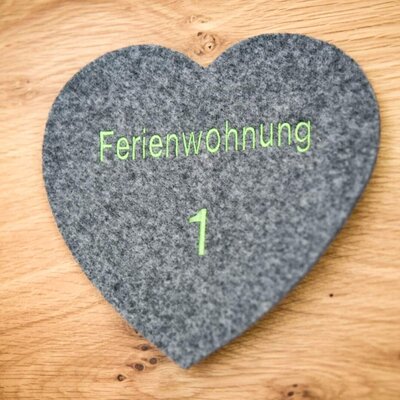 Ein liebevoll gestaltetes Filzherz als Türschild für die Ferienwohnung 1 auf dem Bauernhof.