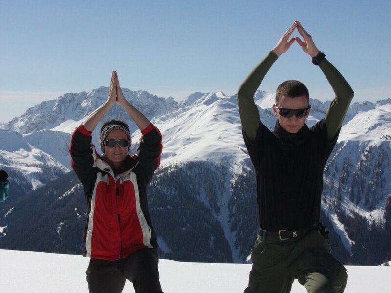 Zwei Personen beim Ausführen einer Pose in der verschneiten Berglandschaft rund um den Bauernhof.