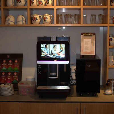 Kaffeestation im Bauernhof mit einer Kaffeemaschine, Teeauswahl und Geschirr.