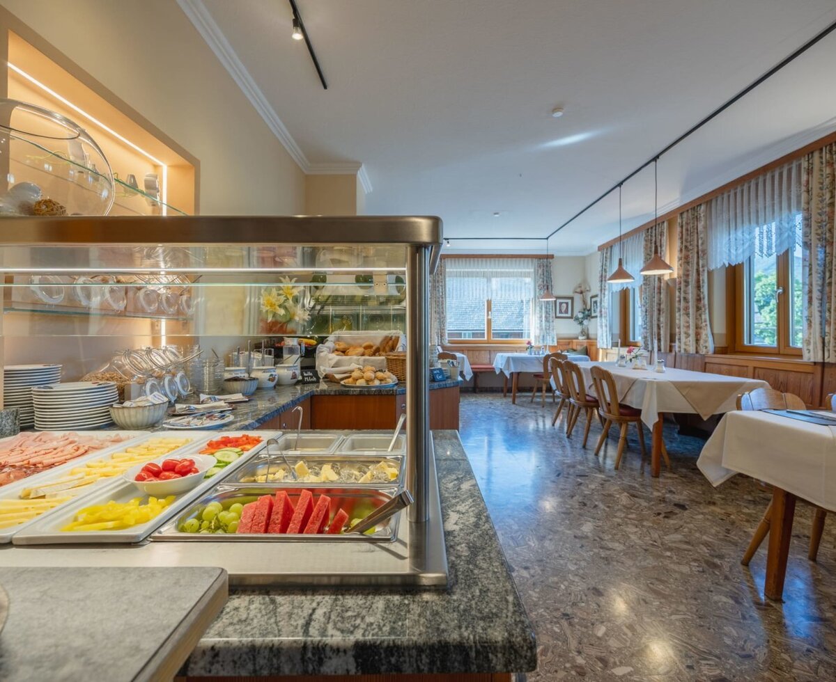 Frühstücksbuffet mit Aufschnitt, Käse, Obst und Gemüse im Essbereich des Bauernhofs.