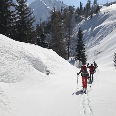 Skitourengeher in der verschneiten Berglandschaft, eine der Winteraktivitäten, die Sie vom Bauernhof aus unternehmen können.