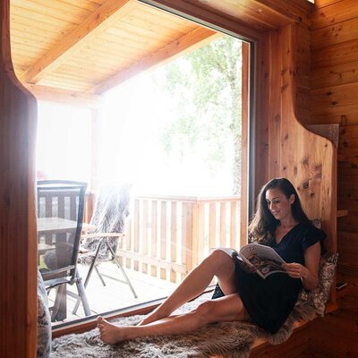 Sitzbereich am Panoramafenster im Chalet mit Fellauflage und Blick auf die Terrasse.