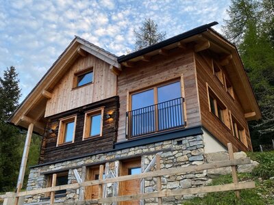 Die charmante Almhütte kombiniert traditionelles Holz und Naturstein in einer idyllischen Hanglage.